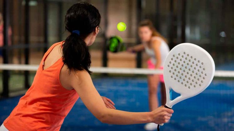 Jugadora de pádel golpea la pelota en pista indoor, ejemplo de deporte no olímpico que opta a las becas 2025 de la Junta de Andalucía