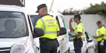 Agentes de la Guardia Civil de Tráfico inspeccionan un vehículo para comprobar la presencia del dispositivo V16 y evitar multas de 200 euros