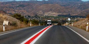 Carretera con línea continua roja pintada por la DGT para prohibir adelantamientos y reforzar la seguridad vial