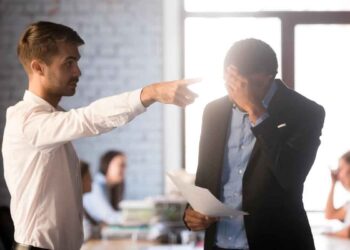 Jefe señalando la puerta a trabajador cabizbajo con carta en la mano, ejemplo de despido improcedente y posible reclamación de indemnización